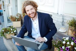 Geschäftsmann (oder Politiker) lächelt, während er am Laptop arbeitet
